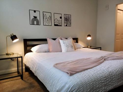 um quarto com uma cama com lençóis brancos e almofadas em "Two Bella" Luxury Apt - POOL - 4 Mi to Beach em Daytona Beach