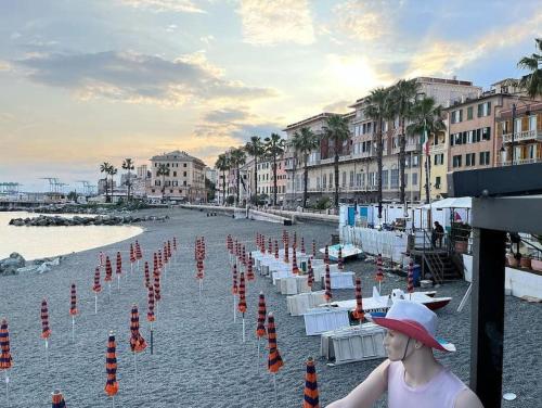 Una donna con un cappello in piedi su una spiaggia di Brezza Marina 3021 a Genova