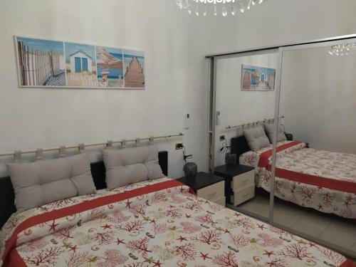 una camera con due letti e uno specchio di Brezza Marina 3021 a Genova