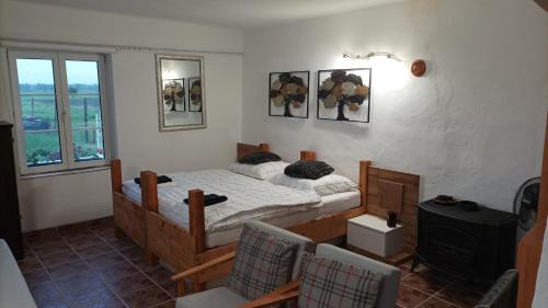 een slaapkamer met een bed en 2 stoelen. bij Guesthouse Tulipán Vendégház 