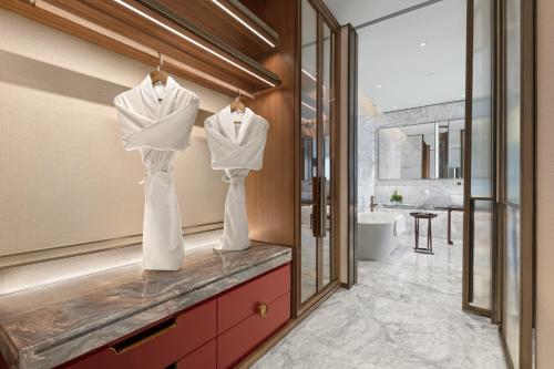 a bathroom with two mannequins on a counter at RiZhao Mumian Hotel in Rizhao