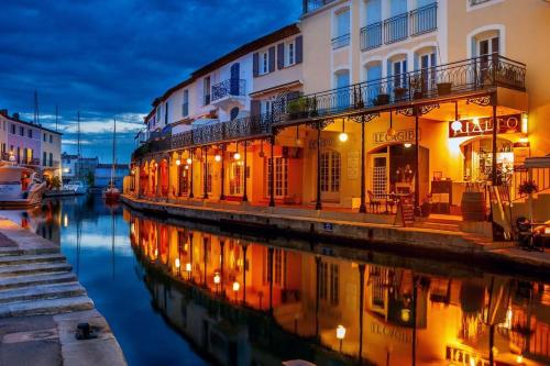 a group of buildings next to a canal at night at Les Golfes Clairs in Grimaud