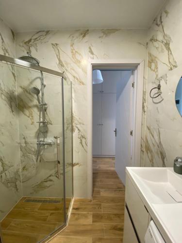 a bathroom with a glass shower and a sink at Apartments LUNA in K'obulet'i