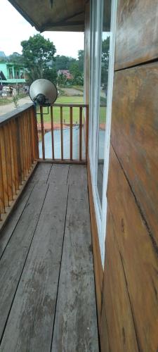 a porch of a wooden house with a window at Purabarang Homestay in Rantepao