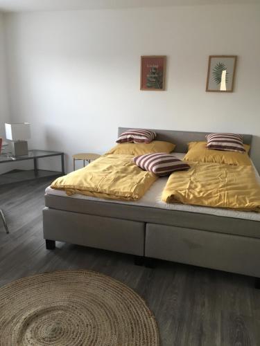 a bed with yellow sheets and pillows in a bedroom at Apartment im Stadthaus in Finsterwalde