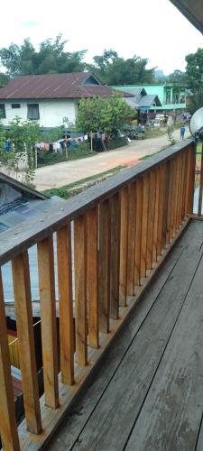 a wooden railing on a deck next to a body of water at Purabarang Homestay in Rantepao