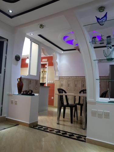 Mira Appartement -Lovely, Tidy & Close to beaches and city center في الحسيمة: مطبخ مع طاولة وغرفة طعام