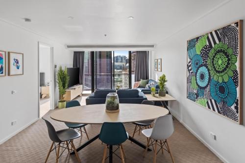 Nook Melbourne Apartments في ملبورن: غرفة معيشة مع طاولة وكراسي وأريكة