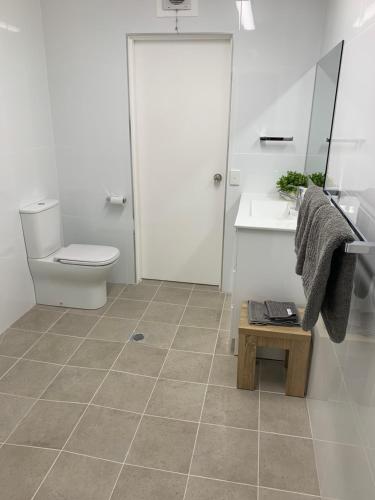 a bathroom with a toilet and a sink and a mirror at Wynyardway in Tumut