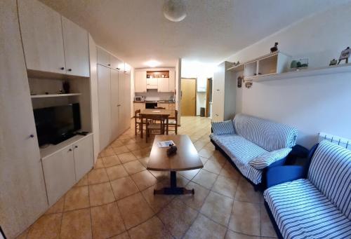 una sala de estar con 2 sofás azules y una mesa. en Appartamento Val di Luce Relax Cristallo, en Abetone