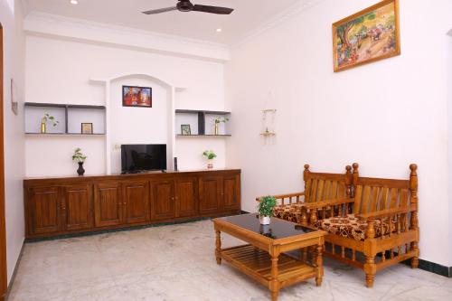 a living room with a couch and a tv at Nanda Gokula Homestay in Auroville