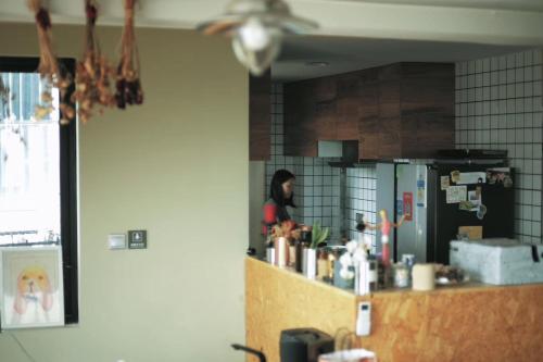 a woman standing behind a counter in a kitchen at Ma Cherie Homestay in Shanghai