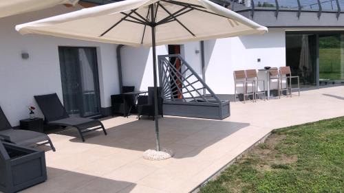 an umbrella on a patio with chairs and tables at Dolomiti Nice1 in Belluno