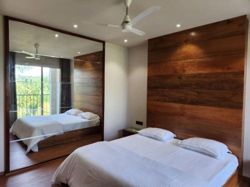 a bedroom with two beds and a large mirror at Gulzar 2BHK Service Apartment, kannur in Kannur
