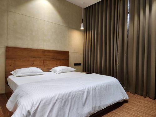 a bedroom with a large bed with white sheets at Gulzar 2BHK Service Apartment, kannur in Kannur
