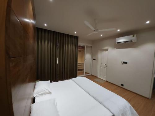a bedroom with a large white bed and a closet at Gulzar 2BHK Service Apartment, kannur in Kannur