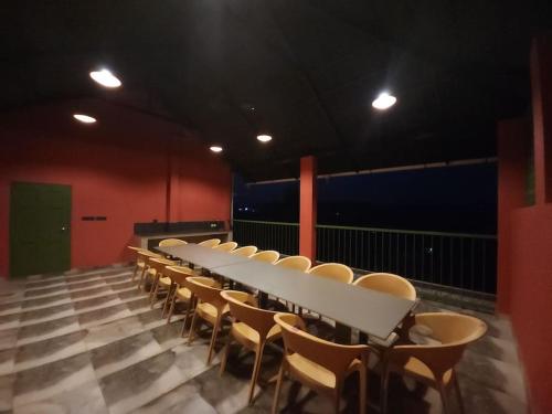 a long white table and chairs in a room at Gulzar 2BHK Service Apartment, kannur in Kannur