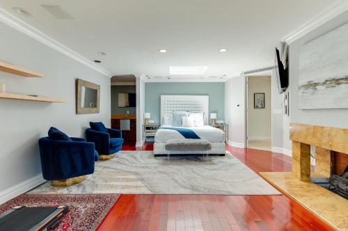 een slaapkamer met een bed en 2 stoelen en een open haard bij Beverly Hills City View Mansion in Los Angeles