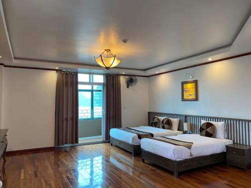 a bedroom with two beds and a chandelier at citybay homestay ha long 3BR in Ha Long