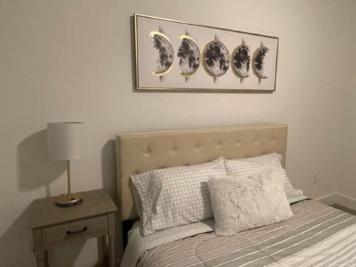 a bedroom with a bed and a night stand with a lamp at Indulge in a luxury apartment in Lawrenceville