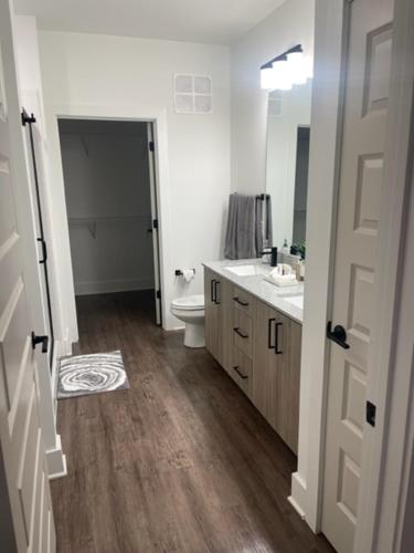 a bathroom with a sink and a toilet and a mirror at Indulge in a luxury apartment in Lawrenceville