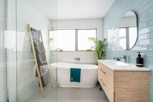 uma casa de banho com uma banheira branca e um lavatório. em PLACE Port Sorell em Port Sorell