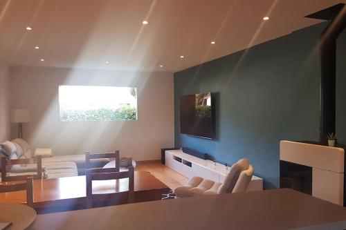a living room with a couch and a table and chairs at Cosy villa with pool near ocean in Labenne