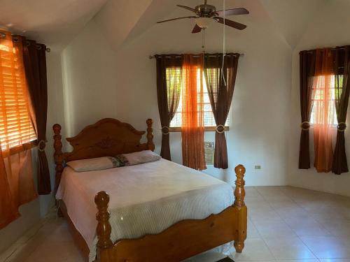a bedroom with a bed and a ceiling fan at La Difference Guest House in Cap-Haïtien