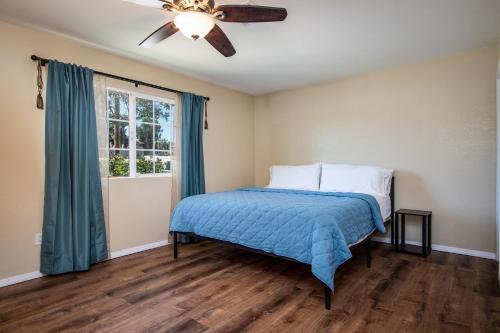 Schlafzimmer mit einem Bett und einem Deckenventilator in der Unterkunft Peaceful Home with Nature Views & Trail Access in Yucca Valley