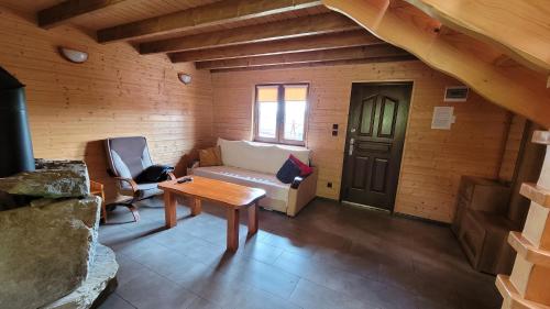 a living room with a couch and a table at domki nad jeziorem in Wołkowyja