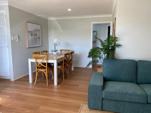 a living room with a table and chairs and a couch at Walk to beach - 3bed House - Pet & kid friendly in Buddina