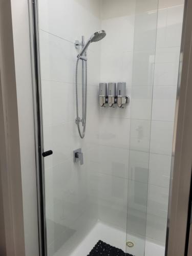 a shower in a bathroom with a glass door at Healesville Schofield Cottage in Healesville
