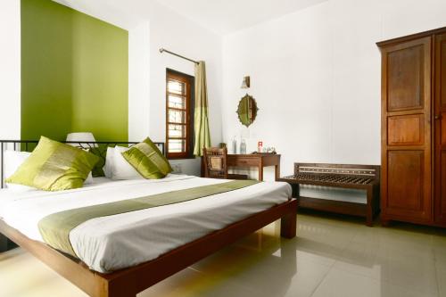 1 dormitorio con 1 cama de color verde y blanco en Laika Boutique Stay en Bangalore