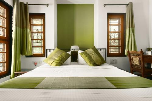 a bedroom with a large bed with green walls at Laika Boutique Stay in Bengaluru