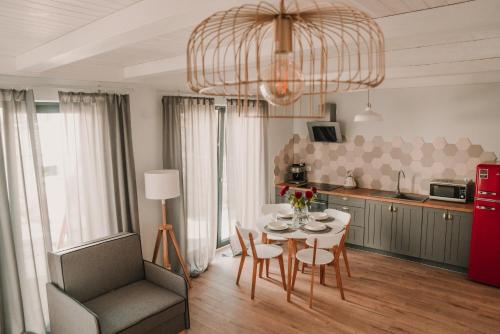une cuisine et une salle à manger avec une table et une chaise dans l'établissement Antresola13, à Supraśl