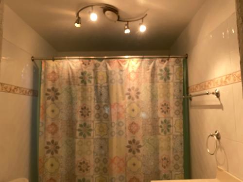 a bathroom with a shower with a shower curtain at La Difference Guest House in Cap-Haïtien