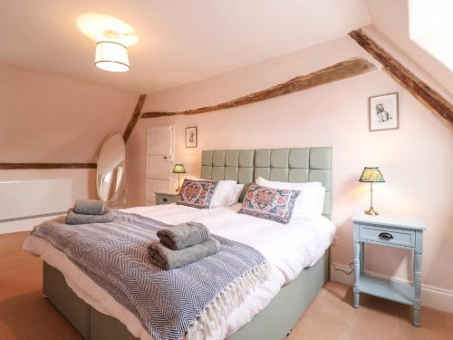 a bedroom with a large bed with towels on it at South Grange Cottage in Saxmundham