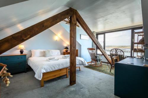 a bedroom with a bed and a large window at Old Coastguard Cottages in Amble