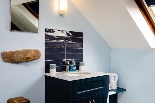 a bathroom with a sink in a room at Old Coastguard Cottages in Amble