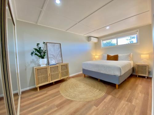 a bedroom with a bed and a window and a rug at Walk to beach - 3bed House - Pet & kid friendly in Buddina
