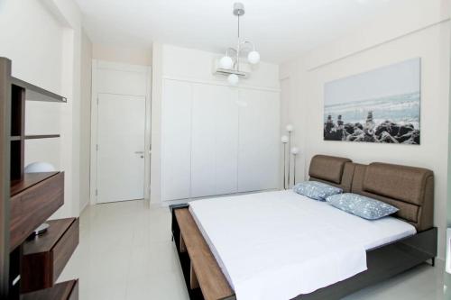 a white bedroom with a bed and a television at Sea Front Residence with Sandy Beach Private Jetty in Bodrum City