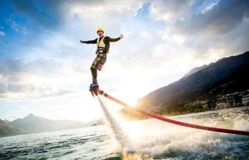 a man is water skiing on the water at Holiday Tourisms Group of Homestay Rooms Scuba Diving Boating Watersports-Tarkarli-Devbag Beach in Bhogwe