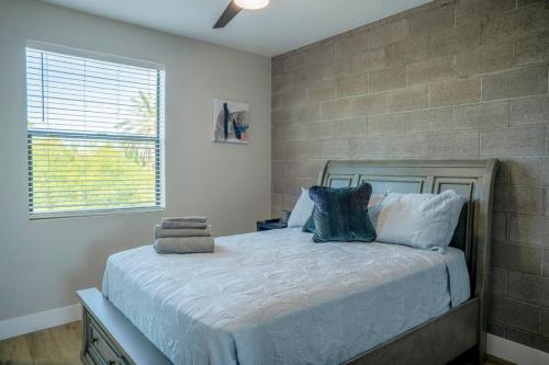 ein Schlafzimmer mit einem Bett mit Ziegelwand in der Unterkunft Clarendon Lux Modern Townhome in Phoenix