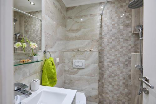 a bathroom with a white sink and a shower at Stone House Biskup in Babino Polje