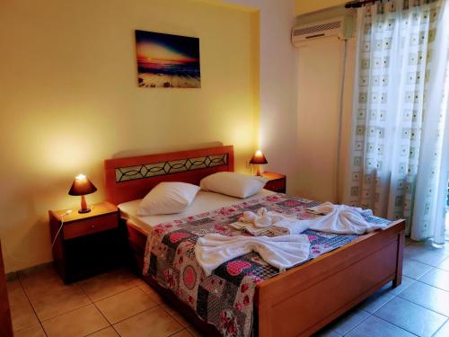 a bedroom with a bed with two night stands and two lamps at IRIS STUDIOS in Agios Nikitas