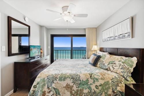 a bedroom with a bed with a view of the ocean at Commodore 609 in Panama City Beach