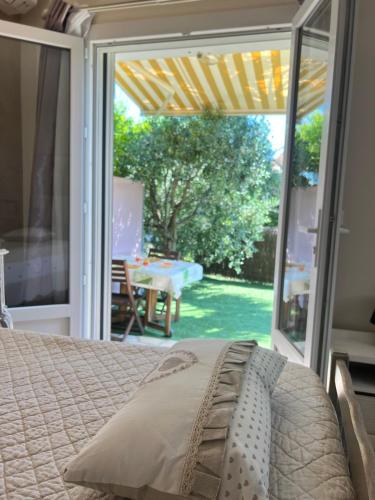 a bedroom with a bed and a sliding glass door at Bastide du Levant - 50m plage - Rez de jardin in Sainte-Maxime