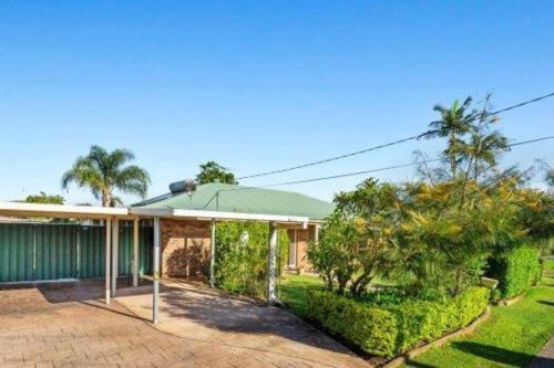 ein Haus mit einem grünen Dach und einigen Bäumen in der Unterkunft Crestmead Cottage in Kingston