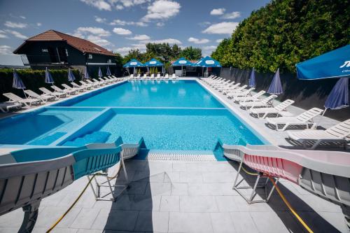 a large swimming pool with lounge chairs and umbrellas at Avalon Hotel&Pool in Yelikhovichi