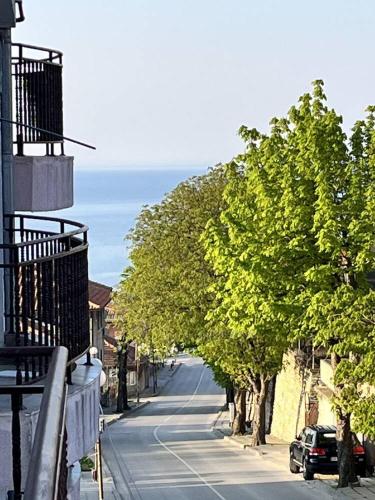 una calle con árboles al lado de un edificio en Луксозен двустаен в Балчик с морска гледка en Balchik